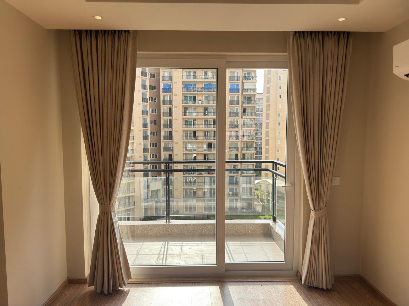 Beige curtains framing a balcony in a living room