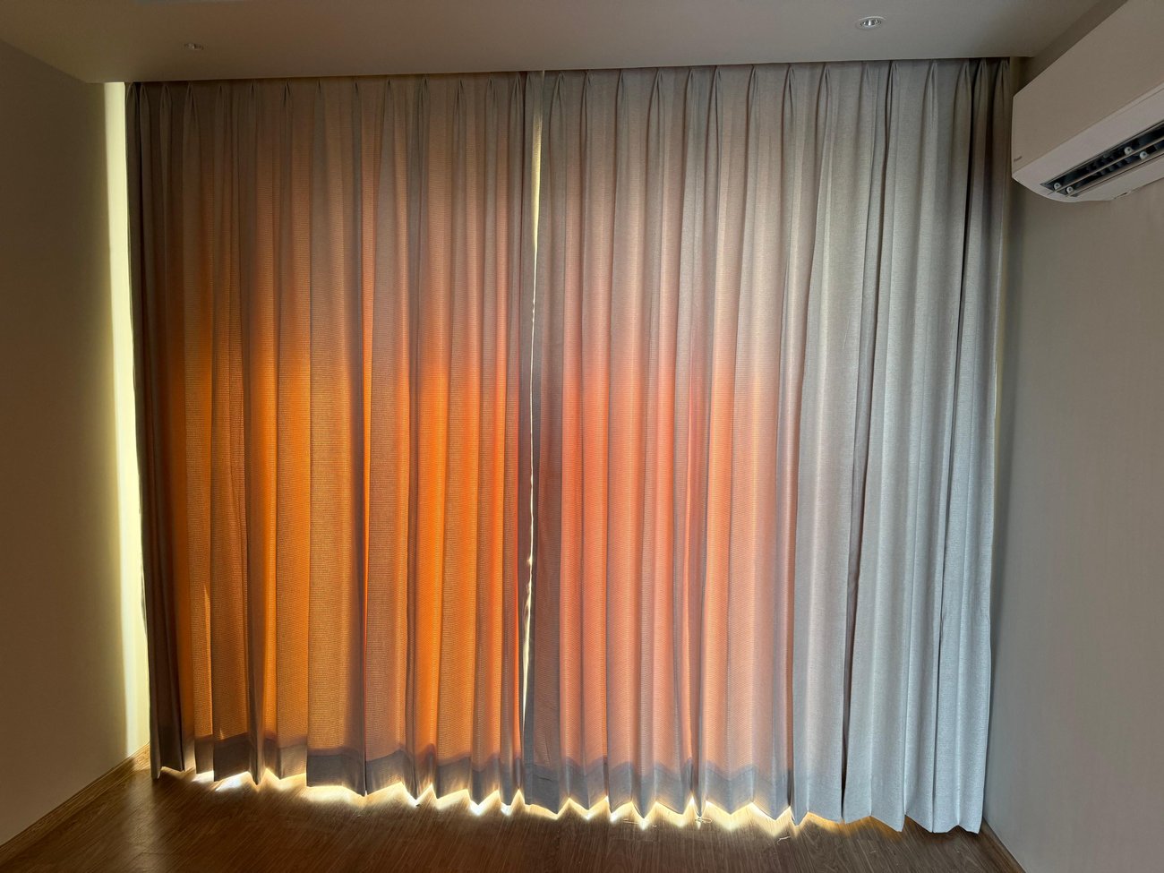 Orange and white sheer curtains in a bedroom