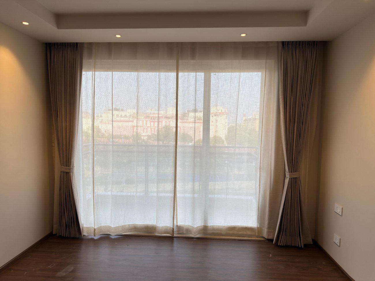 Sheer gold curtains in an empty balcony room